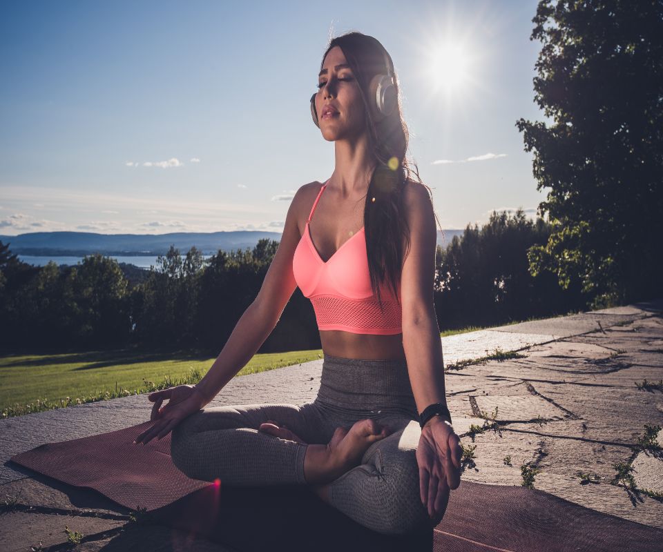 a woman meditating listening to meditation instructions