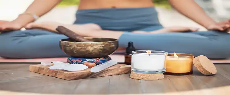 Singing Bowl and some healing stones with candles lit up while performing Yoga and mindfulness exercise @i-am-meditations.com