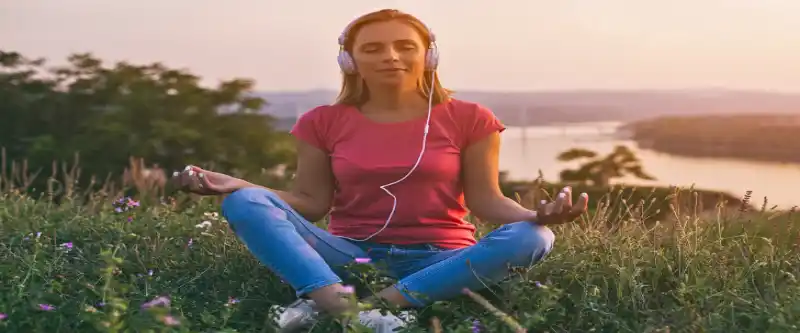 A female meditating and listening to 528 Hz meditation music to improve her creativity and focus. 5 ways meditation can increase creativity and productivity, and the power of meditation music. Learn 5 ways that meditation can increase your creativity @ i-am-meditations.com