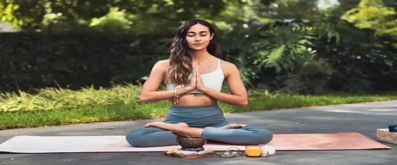Female practicing meditation and yoga with serene candles and a singing bowl. Morning meditation music used for yoga can enhance your practice. Learn more @ i-am-meditations.com