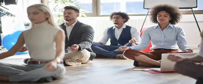 A group of regular individuals meditating in a group session. The benefits of meditation on enhancing relationships. Learn more @ i-am-meditations.com